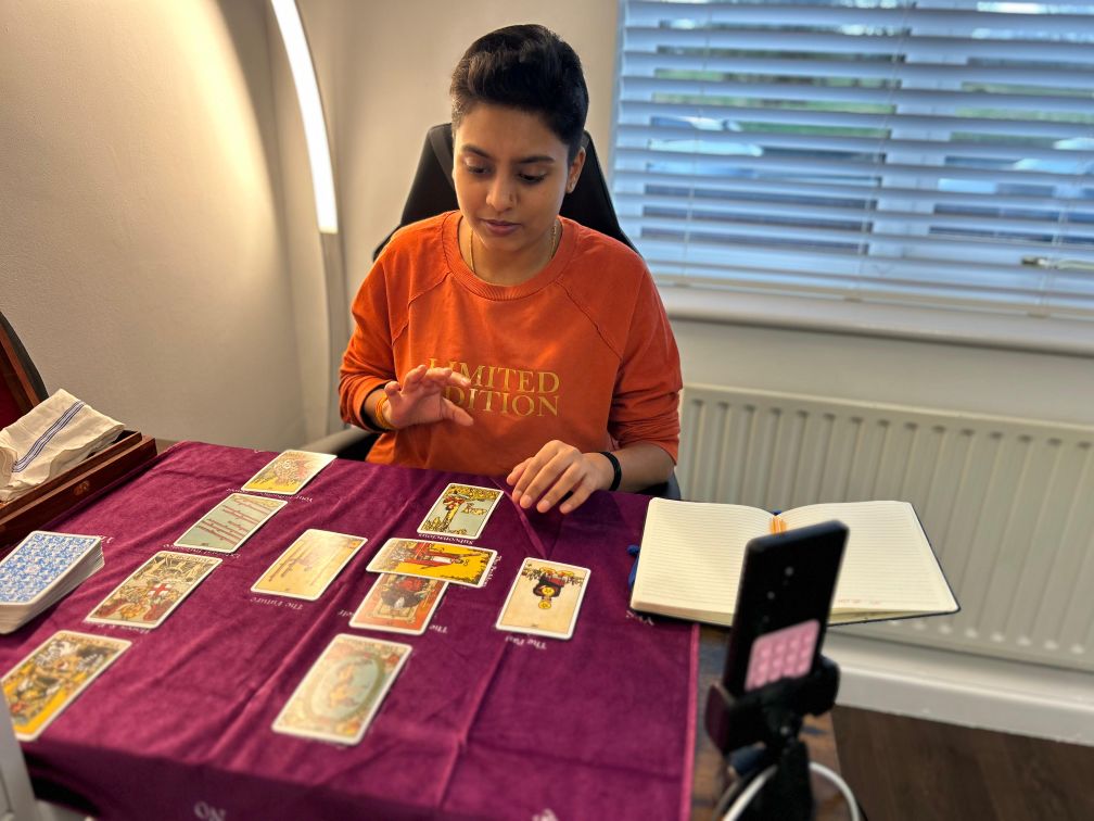 Meha reading Tarot cards at a table